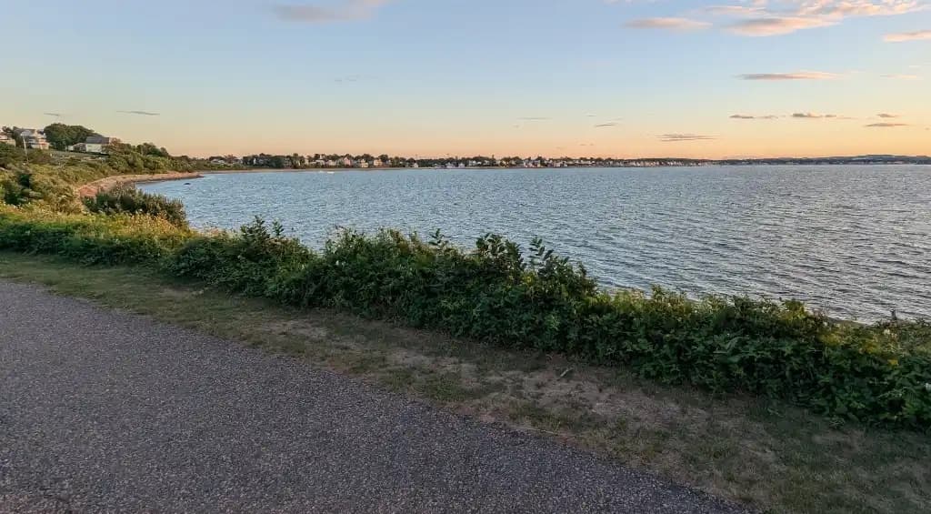 A paved running path along the water at sunset